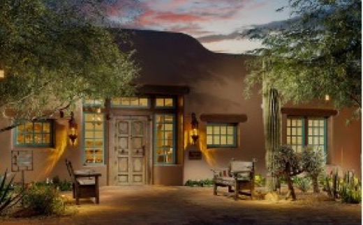 Adobe casita entrance lit by lanterns at dusk